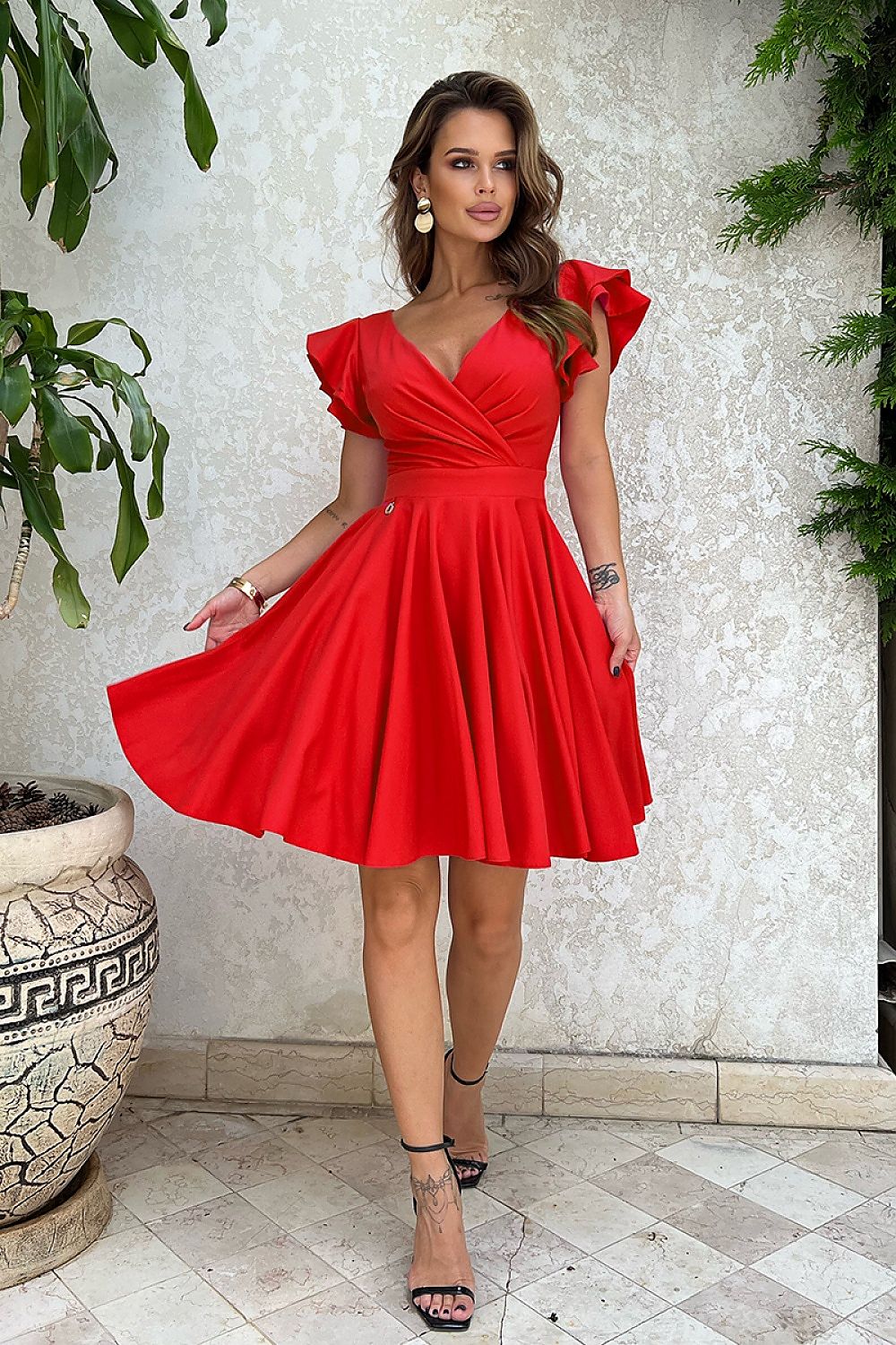 Vrouw in Ruffle Charm taillejurk met ruches aan de mouwen – elegante meisjesachtige jurk